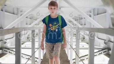 男孩沿着桥下的金属走廊走。 他爬过<strong>舱门</strong>。 很酷的镜头。